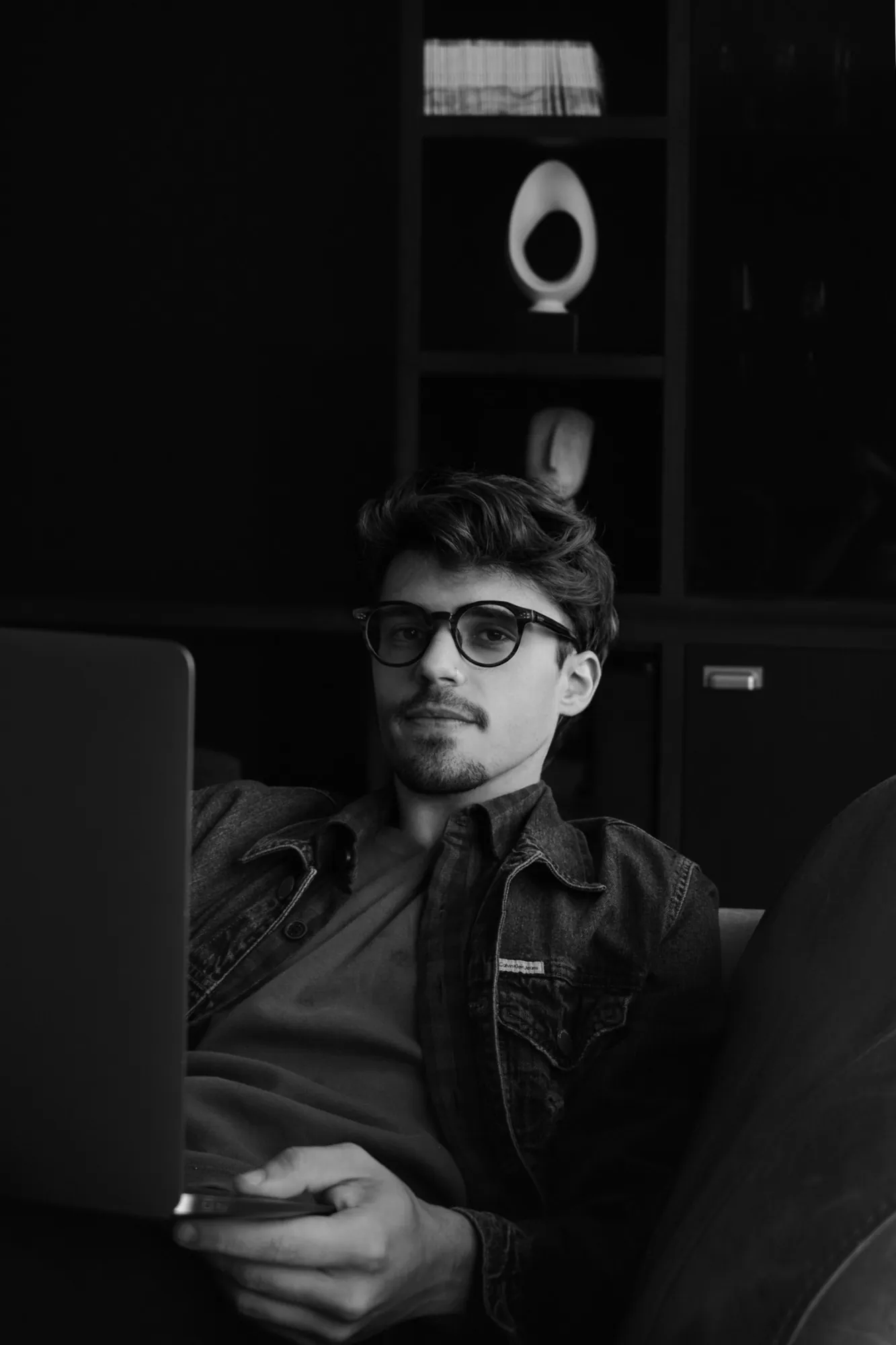 Retrato de Gustavo Tulio, designer UX/UI e de produto, trabalhando no notebook